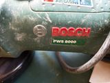 a close up of a bosch power drill on a table