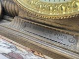 a gold clock sitting on top of a marble table