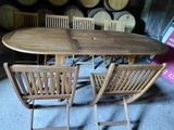 une table et des chaises dans une cave à vin, avec des tonneaux en arrière-plan