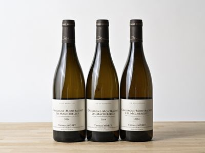 three bottles of wine sitting on top of a wooden table
