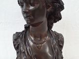 une image représentant un buste de femme en bronze posé sur un socle en bois