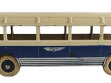 un petit bus en plastique posé sur une surface blanche