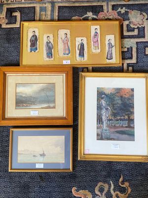 many framed pictures on the wall of a room