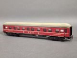a red train car that is sitting on a gray surface