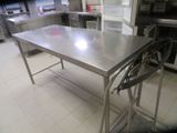 a stainless steel table in the middle of a kitchen