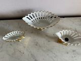three white and gold dishes on a marble table