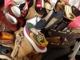 un tas de chaussures et de sacs à main sur un lit
