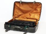 une valise noire dont le couvercle est ouvert, posée sur une surface blanche