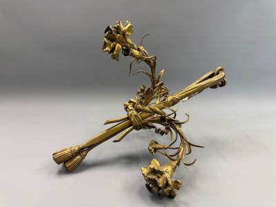 figurine plaquée or, ornée de fleurs et de feuilles, sur un fond blanc