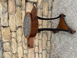 a wooden table with a marble top sitting on a stone wall