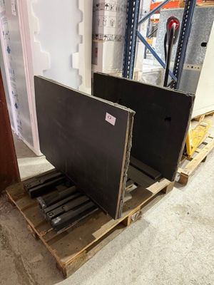 two televisions sitting on a pallet in a warehouse