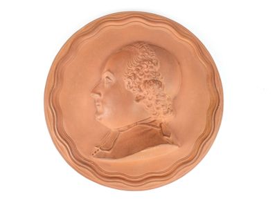 une image représentant un médaillon en bronze avec le profil d'un homme