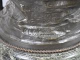 a close up of a silver vase with a bird on it