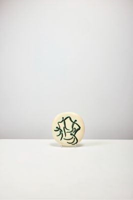 une image représentant un bouton orné d'un dessin, posé sur une table