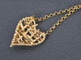 a gold necklace with a heart shaped basket hanging from it