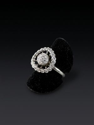 a white gold and diamond flower ring on a black velvet ring holder