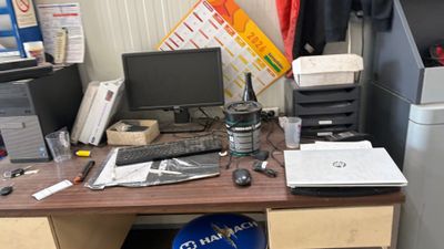 un bureau sur lequel se trouvent un ordinateur, une imprimante, une souris et d'autres objets