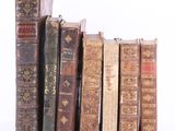 plusieurs vieux livres sont alignés sur une surface blanche