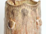 a brown vase with holes in it on a white surface