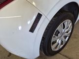 a close up of a white car with a sticker on it