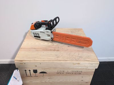 an orange chainsaw sitting on top of a wooden box