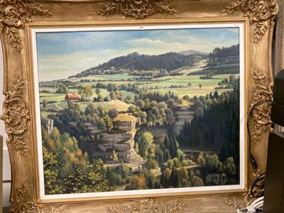 une photo d'un tableau représentant un paysage dans un cadre doré