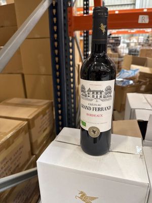 une bouteille de vin posée sur des cartons dans un entrepôt