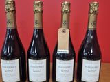 quatre bouteilles de vin sont alignées sur une table en bois