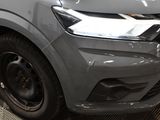 the front end of a silver truck with a black stripe on it ' s bumper