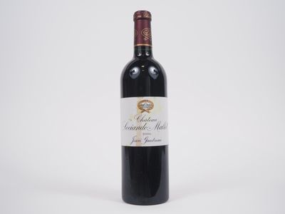 une bouteille de vin rouge posée sur une table blanche