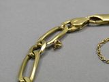 gros plan d'un bracelet en or avec une chaîne
