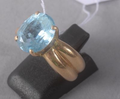 a gold ring with a blue topaz stone on it