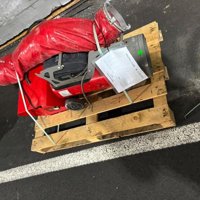 une borne d'incendie rouge posée sur une palette