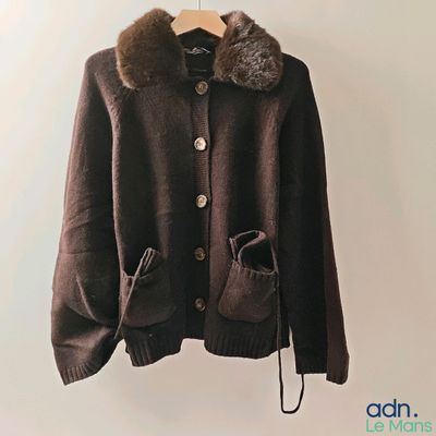 brown jacket with fur collar and cuffs hanging on a hanger