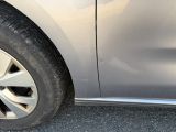 un chat assis sur le côté d'une voiture argentée