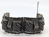 an image of a close up of a metal bracelet with a chain