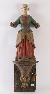 une vieille statue en bois représentant une femme debout sur une caisse