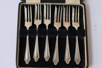 six fourchettes et une cuillère dans un étui posé sur une table