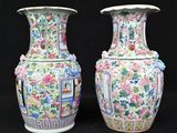 pair of chinese vases with floral designs on them against a black background