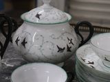 a tray with a tea pot, cups, and saucers on it