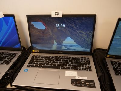 four laptops are lined up on a table with price tags on them