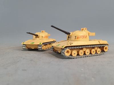 two toy tanks sitting side by side on a table