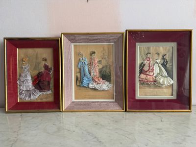 trois photos encadrées représentant des femmes en robe sont posées sur une table