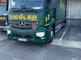 a green truck that is parked in a parking lot