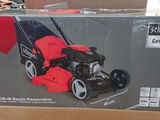 the box of a lawn mower sits on the floor in the store