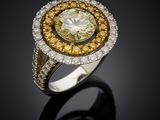 a yellow and white diamond ring on a black surface