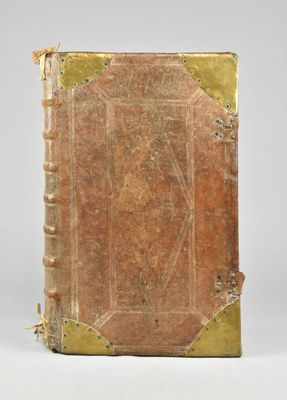 un gros plan d'un livre à la couverture dorée posé sur une surface blanche