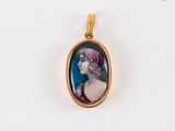 Un pendentif plaqué or représente une femme ovale portant un bandeau rose.