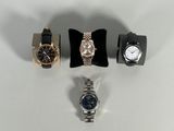 three watches and a watch band are sitting on a white surface