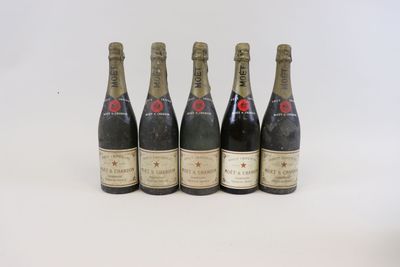 quatre bouteilles de champagne sont alignées sur une surface blanche